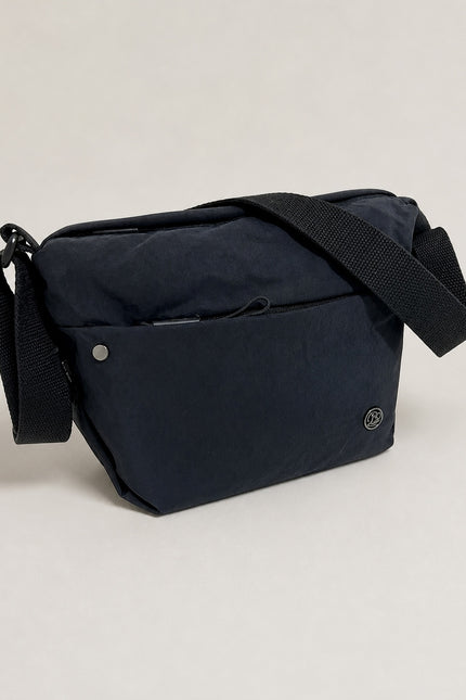 Grand sac banane femme en nylon avec poches zippées — vue trois-quarts sur fond gris clair