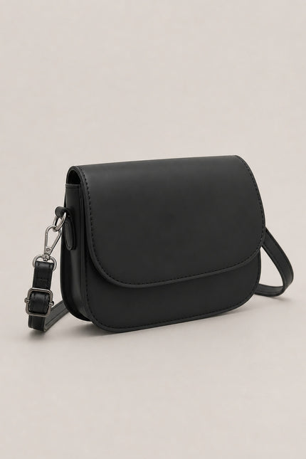 Petit sac bandoulière en similicuir à rabat — vue trois-quarts sur fond gris clair