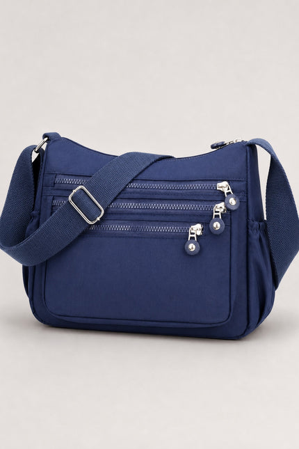 Sac bandoulière femme en tissu Oxford multi-poches — vue trois-quarts sur fond gris clair