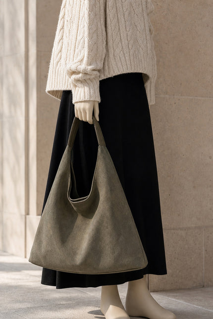 Sac besace femme en suédine avec pochette — porté à la main en vue rapprochée