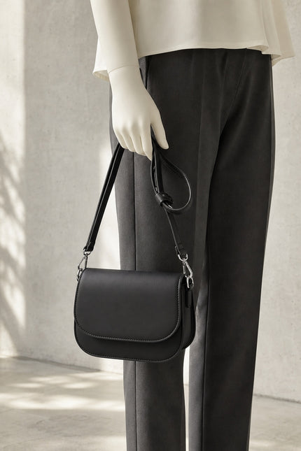 Petit sac bandoulière en similicuir à rabat — porté à la main en vue rapprochée