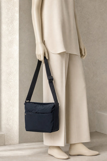 Grand sac banane femme en nylon avec poches zippées — porté à la main en vue rapprochée
