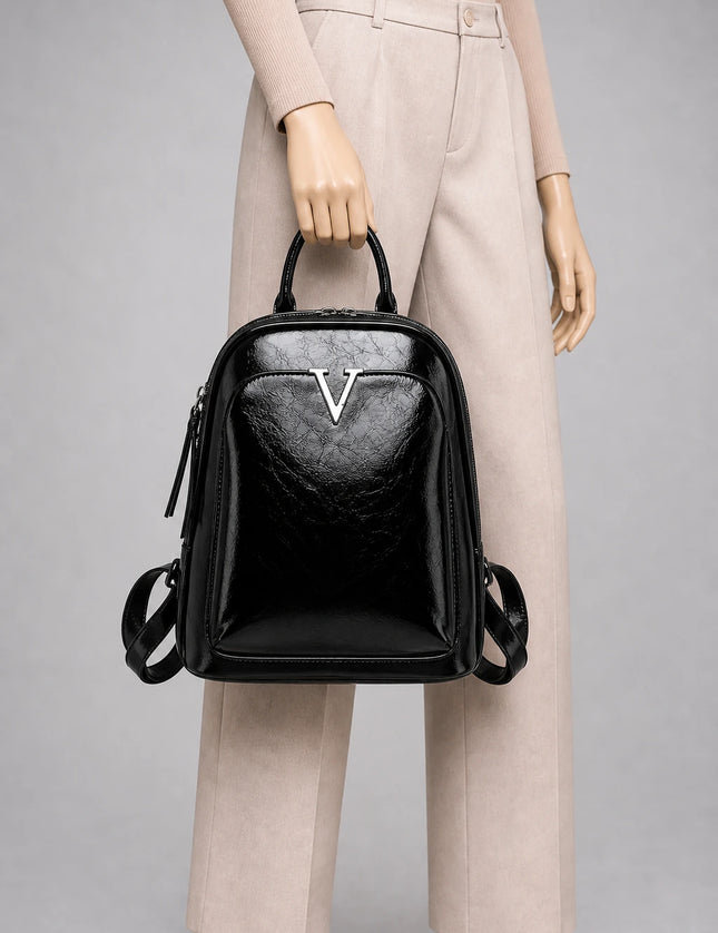 Sac à dos cuir verni femme élégant et imperméable porté à la main en studio - Aurean Paris - source inputs